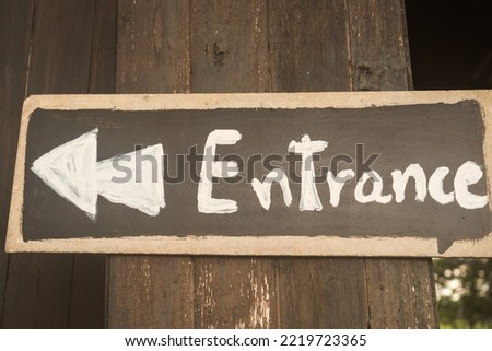Entrance tex sign wooden board bouquet on door at front of cafe or rent house with wood background. Business service sign