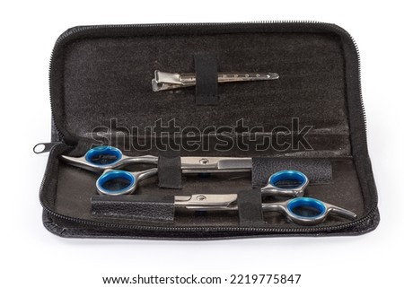 Set of two different professional stainless steel hairdressers scissors in the open leathern case on a white background, close-up in selective focus
 Royalty-Free Stock Photo #2219775847