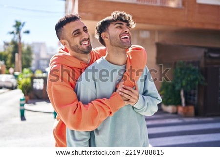Two man couple hugging each other standing at street Royalty-Free Stock Photo #2219788815