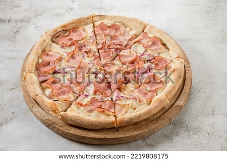 Fresh pizza with meat and ham on the concrete background