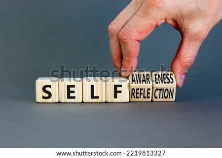 Self reflection awareness symbol. Concept words Self reflection and self awareness on cubes. Beautiful grey background. Psychologist hand. Psychological self reflection awareness concept. Copy space