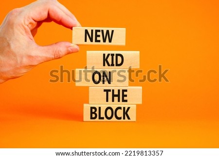 New kid on the block symbol. Concept words New kid on the block on wooden blocks. Businessman hand. Beautiful orange table orange background. Business and new kid on the block concept. Copy space.