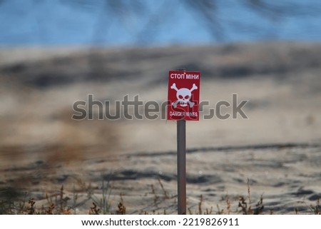 A bright red "Danger-mines" sign was placed on the sandy beach of Odessa during the Russian attack on Ukraine. Putin sucks.