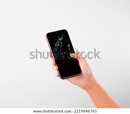 Hand Held Broken screen mobile phone white background Royalty-Free Stock Photo #2219846765