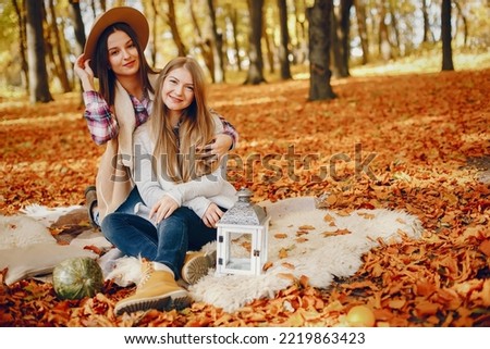 Beautiful girls have fun in a autumn park