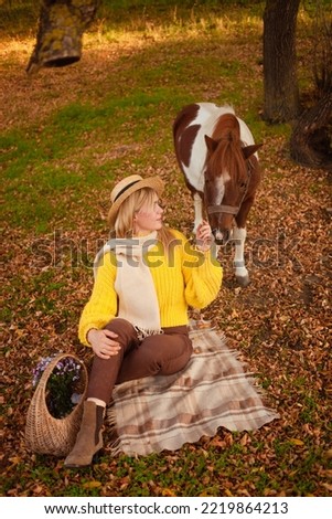 Beautiful picture, autumn nature, woman and horse, concept of love, friendship and care. background. picnic