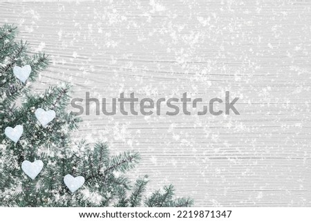 fir branches with snow on a white wooden table, christmas background