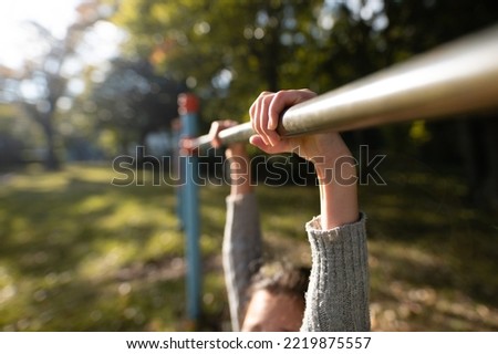 Child's hand playing horizontal bar in the park Royalty-Free Stock Photo #2219875557