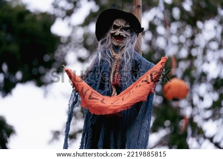 Ghost doll hanging in the front yard of the haunted house was decorated for a Halloween night party on blur natural tree, to celebrate on Halloween day