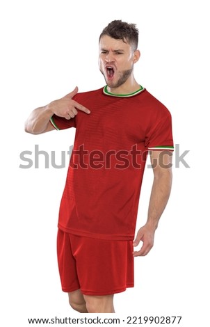 Professional soccer player with a IR IRAN national team jersey shouting with excitement for scoring a goal with an expression of challenge and happiness on a white background. Royalty-Free Stock Photo #2219902877
