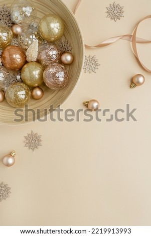 Aesthetic creative arrangement of colourful golden, beige Christmas balls and toys on neutral beige background. Flat lay, top view
