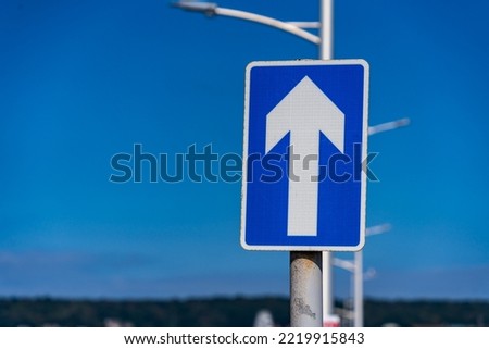 One way sign set against a blue sky	
