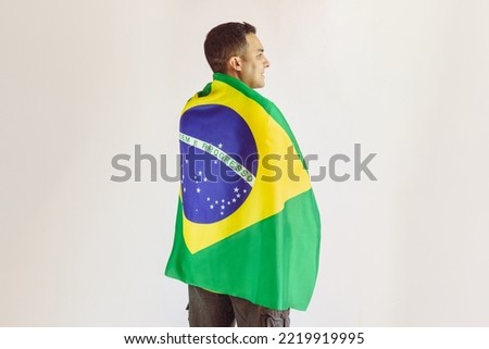 Black Man Holding Brazilian Flag With Soccer Team Yellow Shirt Isolated on White. Sport Fan Cheering for Brazil to be the champion. Royalty-Free Stock Photo #2219919995