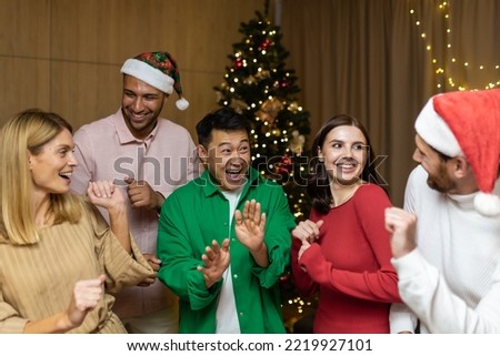 Cheerful Group friends celebrate New Year's party at home dancing together Christmas eve having fun. house New Year party. spending Time Together Holidays Mood funny man and woman.