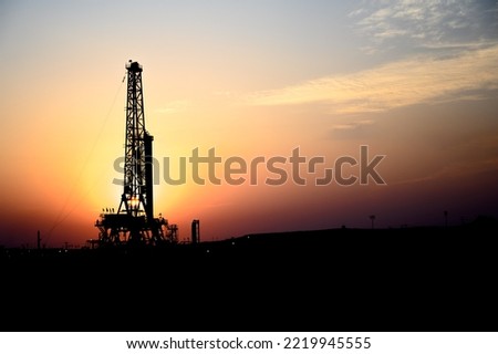 Silhouette of drilling rig in oilfield at sunset golden hour- Close up Royalty-Free Stock Photo #2219945555