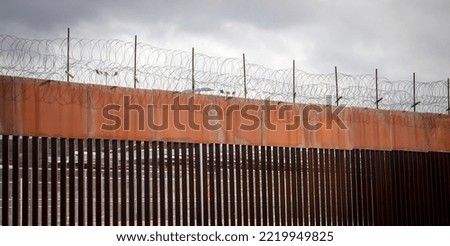 Border wall with barbed wire Royalty-Free Stock Photo #2219949825