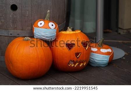 Decorating autumn pumpkins at home. Traditional Thanksgiving and Halloween decor. Goods of the autumn. Pumpkins with a medical mask. Poland