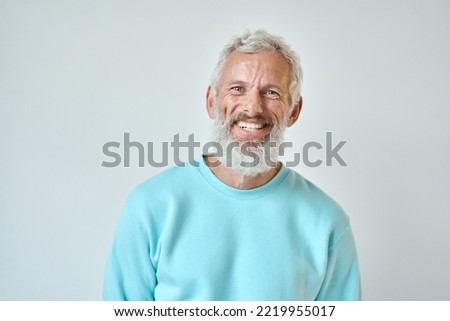 Happy mature old bearded man with dental smile, cool mid aged gray haired older senior hipster wearing blue sweatshirt standing isolated on white background looking at camera, headshot portrait. Royalty-Free Stock Photo #2219955017