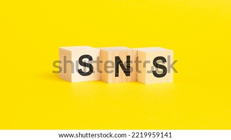 a technical term of SNS on wooden cubes on yellow background, social networking service