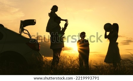 Father mother child play with ball rays sun laugh joyfully. Happy family playing with ball near car sunset. childhood dream trip. kid with parents picnic forest. silhouette happy family with children