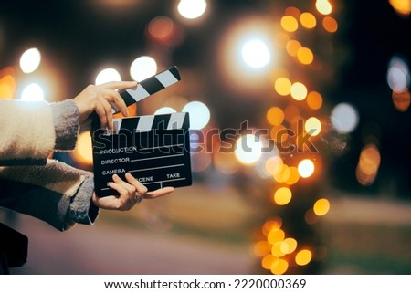 
Director Holding a Film Slate Outdoors on a Christmas Movie Set. Filmmaker producing a show about the winter holidays
