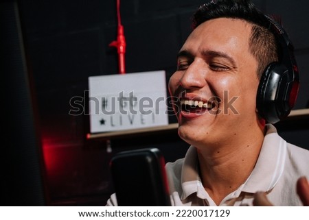 Host Talking and smiling on mic in a stream, podcast show, with headset (headphones) red and black background