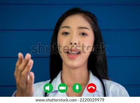 Young Asian woman doctor looking at camera on webcam screen with video call icons, online video conference with patient, and remote medical chat consultation. Telemedicine with female physician.