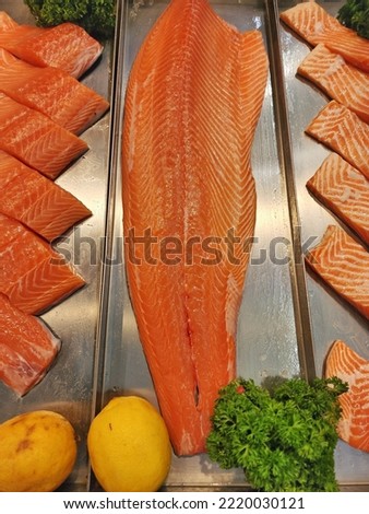 Fresh salmon fillet, beautiful orange color, cut into pieces for Japanese cooking, placed on ice.  Sold in seafood  Some blur in the picture