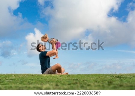 Happy father and daughter playing on grass lawn. Fatherhood, and parenting concept. 