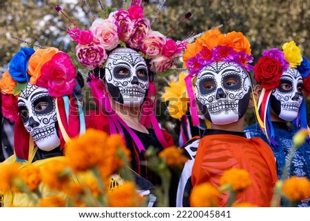SAN ANTONIO, TEXAS - 10.29.2022 - Four women wearing traditional Dia de Los Muertos sugar skull masks participate at the famous Hispanic celebration. People at Day of The Dead festival in South Texas Royalty-Free Stock Photo #2220045841