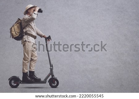 Vintage style explorer riding a scooter and using binoculars, blank copy space