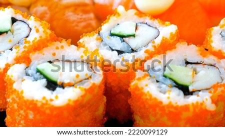 Close up of japanese sushi roll serving in restaurant. Freshly cooked portion of California sushi with crab sticks meat, cucumber and tobico caviar. Japan restaurant menu. Gourmet healthy asian food