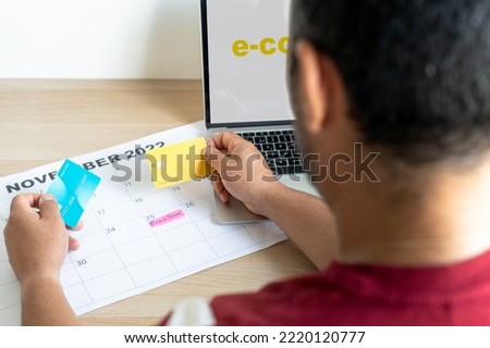 Unrecognizable person deciding which credit card to use for online shopping. Marking black friday on the calendar. High quality photo