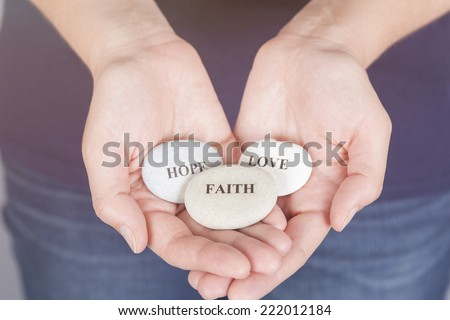 Three stones with the words "Faith", "Hope", "Love" in the woman's palms. Royalty-Free Stock Photo #222012184