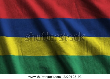 Mauritius flag with big folds waving close up under the studio light indoors. The official symbols and colors in fabric banner
