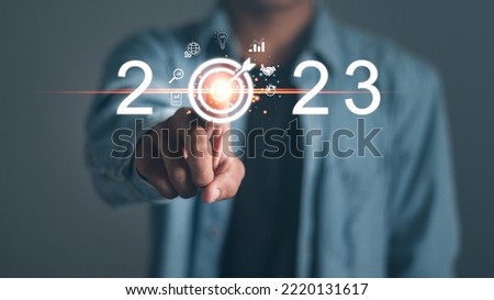 Businessman touching target icon on virtual screen. Startup business 2023. merry Christmas and happy new year concept. 