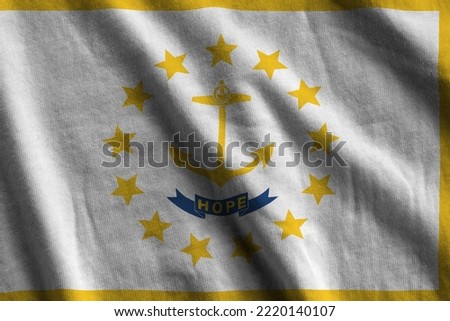 Rhode Island US state flag with big folds waving close up under the studio light indoors. The official symbols and colors in fabric banner