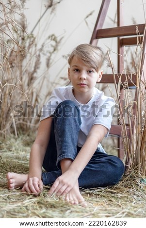 portrait cute boy in mock up white tee shirt in location with dry grass in retro vintage style, copy space