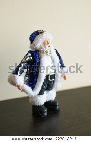 Christmas figurine of Santa Claus in blue clothes made of sequins, close-up photo