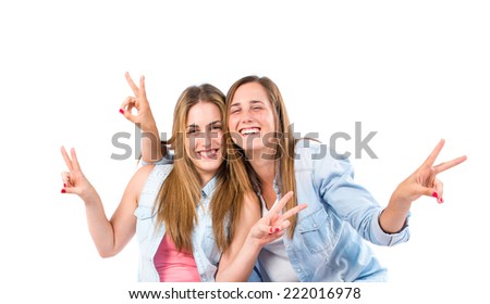 Sisters doing victory gesture over white background