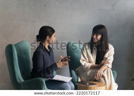 Negotiations of two multi ethnic businesswomen in modern office. Indian female applicant pass job interview, answers to HR manager during formal meeting in workspace. Teamwork, business, communication Royalty-Free Stock Photo #2220172117