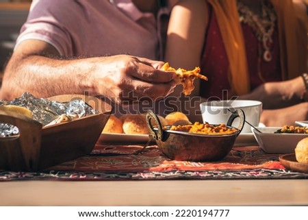 Close-up of Indian father's hand Picking up Indian food, which is to food culture of Indians, to Indian family and food concept. Royalty-Free Stock Photo #2220194777