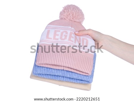 Stack of warm hats in hand on white background isolation
