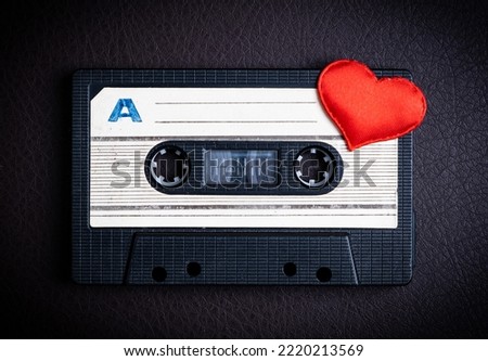 Audio Tape Cassette with a Red Heart on the Dark Background closeup