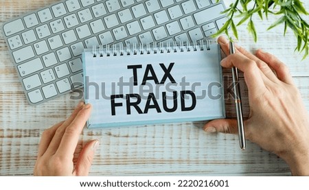 Tax Fraud text on notepad on write office desk.