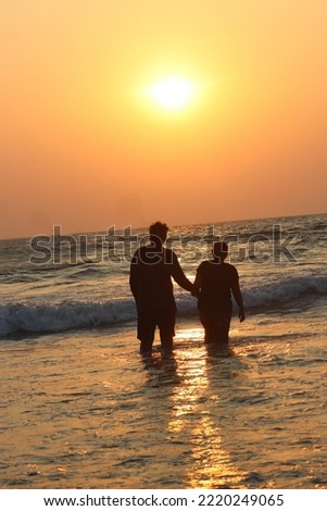 A Shadow couple of lovers enjoying a lovely beach sunset background stock photo