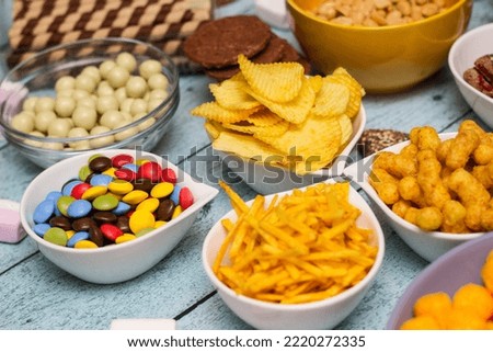 Table of salty and sweet snacks. Large group of unhealthy food Royalty-Free Stock Photo #2220272335