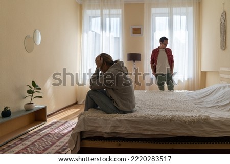 Upset Caucasian woman sits on bed covering face with hands after quarrel with husband man or family bullying and shaming. Crying girl is stressed after learning about upcoming breakup with fiance Royalty-Free Stock Photo #2220283517