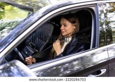 Safety first. Beautiful caucasian lady fastening car seat belt. Pretty young woman driving her new car. Pretty young woman driving her new car.