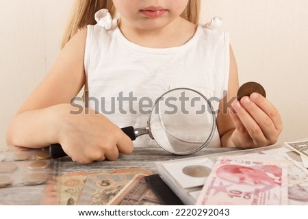 Child with different coins and banknotes, soft focus background